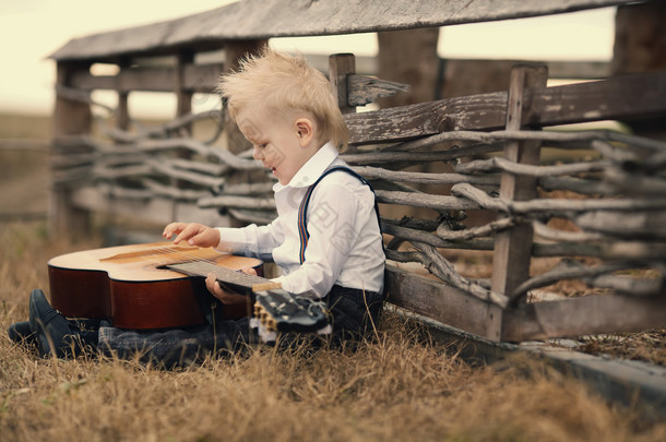 χαριτωμένο μικρό αγόρι με κιθάρα