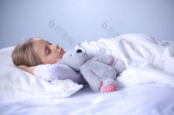 儿童小女孩睡在床上有一只<strong>玩具</strong>泰迪熊.