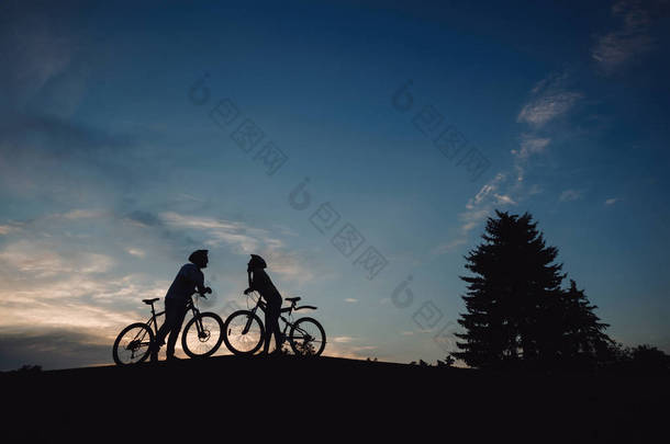 两个骑自行车的晚上天空背景.