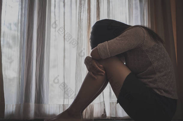 悲伤的女人抱着她的膝盖和哭时独自一人坐 
