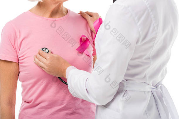 医生用听诊器检查<strong>乳房</strong>癌患者的健康状况与乳腺癌的认识丝带隔离在白色
