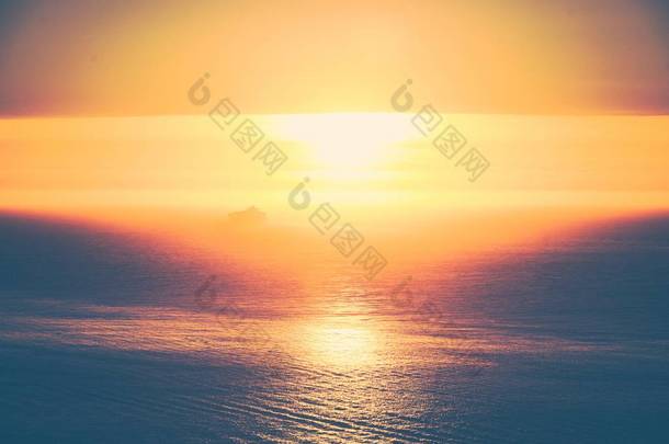 旧金山普雷西迪奥日落时分反射太阳的大海，远处有一艘船