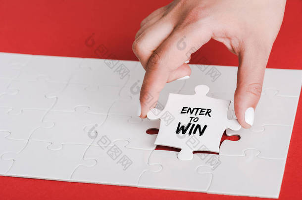 裁剪的妇女拿着拼图与进入赢得字母近连接白色拼图片上的红色