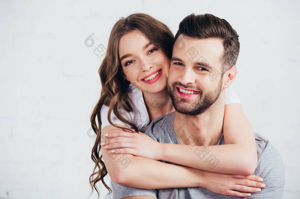 选择焦点幸福的夫妇拥抱和微笑在白色的卧室