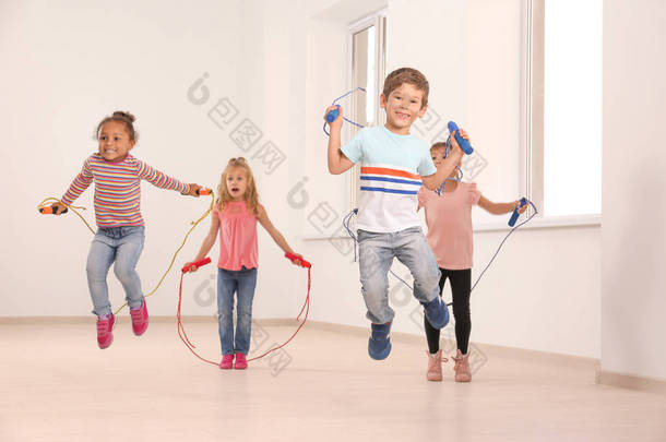 可爱的孩子们在灯光室跳绳