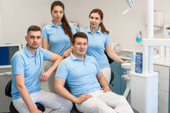 一群年轻而快乐的牙科医生在牙科诊所彼此站在一起。团队合作和业务理念.