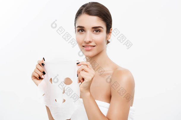 美容护肤理念-美丽的白种女人在她脸上涂纸面膜白色背景.