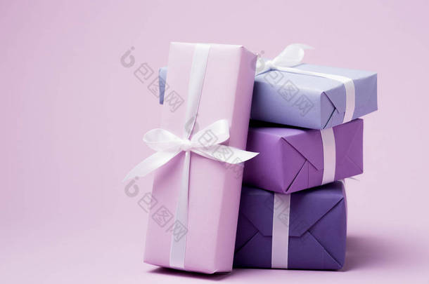 五颜六色的礼品盒，紫色表面有白色丝带