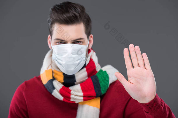 病人在温暖的围巾和医疗面具与停止标志, 隔绝在灰色