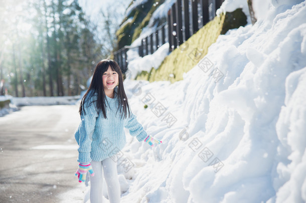 亚洲女孩在雪中户外微笑在寒冷的冬天里