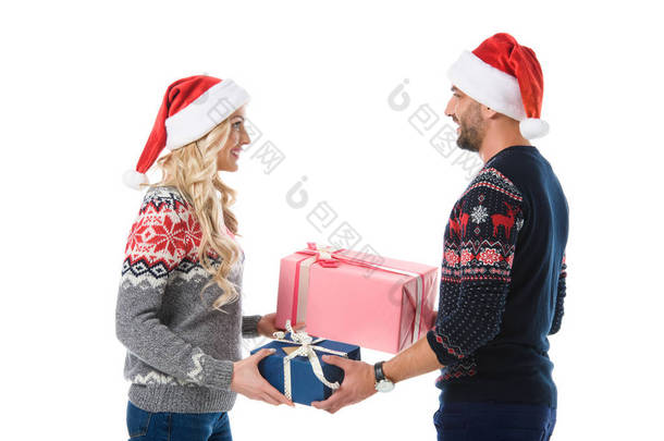 情侣在圣诞毛衣和圣诞老人帽子<strong>送礼</strong>礼物, 孤立的白色