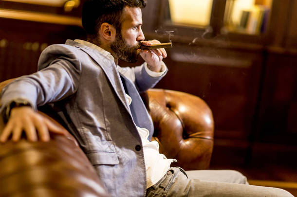 英俊的男人吸烟雪茄