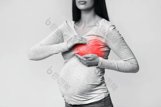 无法辨认的怀孕妇女有<strong>乳房</strong>疼痛站在工作室里，被割伤