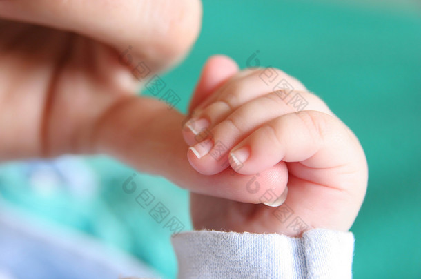 新出生的婴儿手母亲手指夹紧