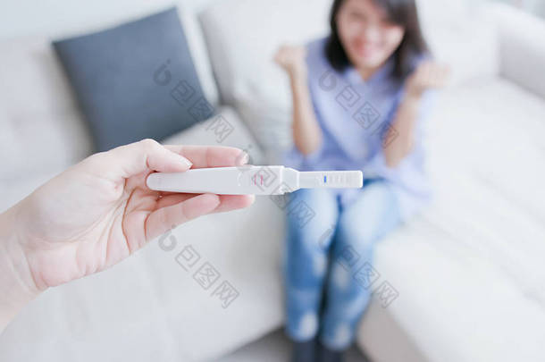 兴奋的女人分享怀孕测试<strong>棒</strong>, 并透露她怀孕了她的丈夫