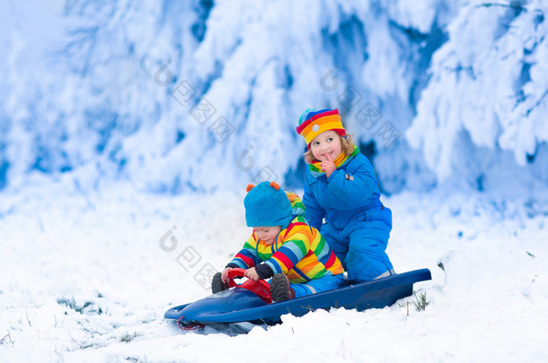 在雪橇上玩耍的孩子骑在冬天
