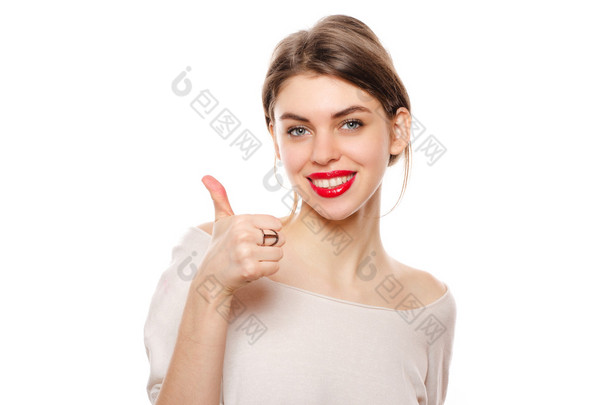 快乐微笑着年轻美丽的女人显示竖起大拇指手势，孤立在白色的背景