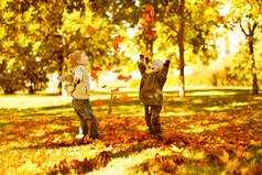孩子们在公园里玩秋天落叶游戏