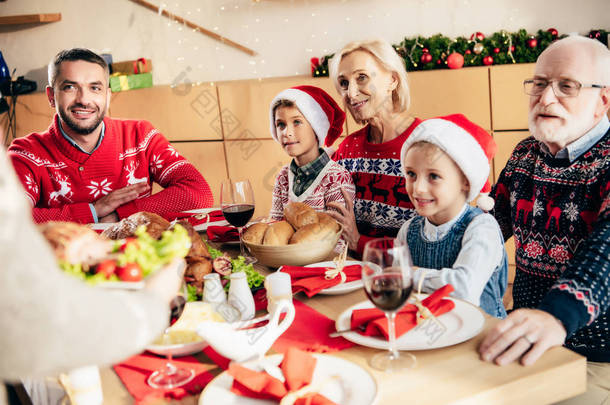 在餐桌上与快乐家庭一起吃圣诞<strong>大餐</strong>的妇女的裁剪图像