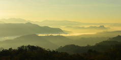 美丽的天空和金色的云彩。日出前的群山。清晨。太阳从山顶升起.