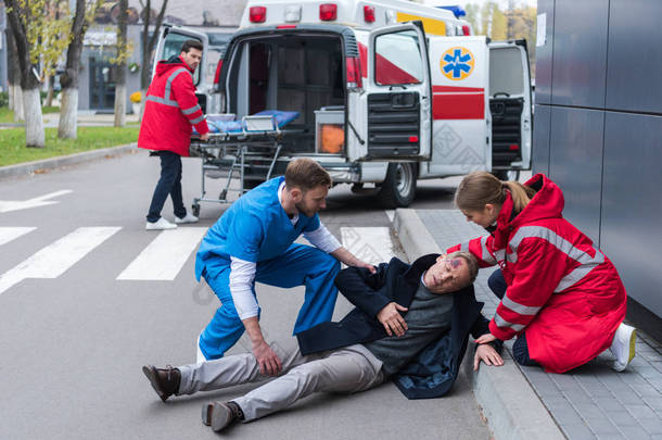 医生帮助受伤的人躺在街上