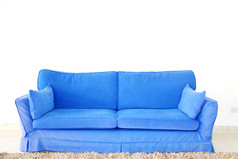 空白的墙上的蓝色双人沙发