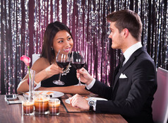 夫妇敬酒在餐厅桌上的酒杯