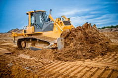 挖掘机工作用泥土和沙子在公路施工现场的沙坑