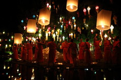 泰国僧人打坐周围之间许多灯笼尊佛像 