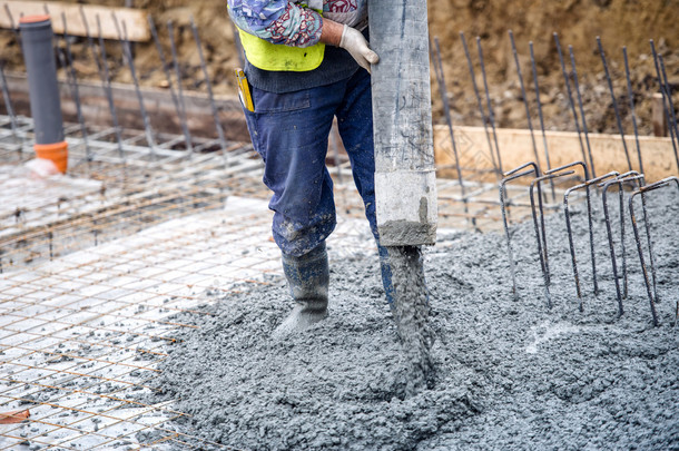 建筑施工工人浇注水泥或混凝土的泵管 