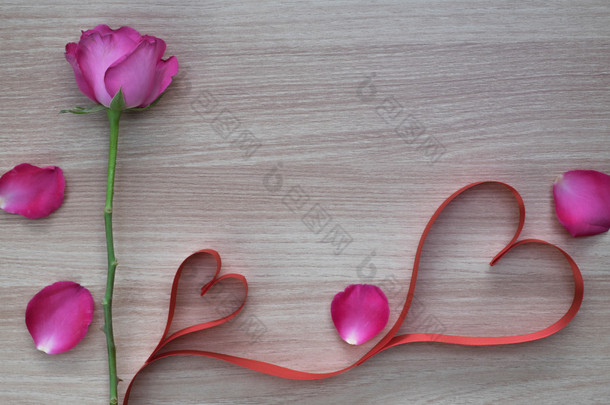 两个红色的心形状带粉红色的玫瑰和花瓣上木制表面与文本的空间