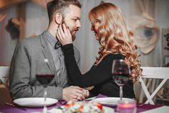 美丽、 年轻夫妇带着眼镜的红酒在豪华餐厅