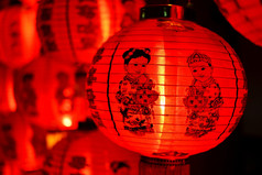 在红色的中国红灯笼旁边，可以看到中国小孩的身影和背景