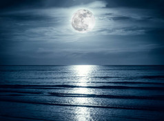 色彩斑斓的天空，乌云与皎洁的月亮在海景。宁静自然背景.