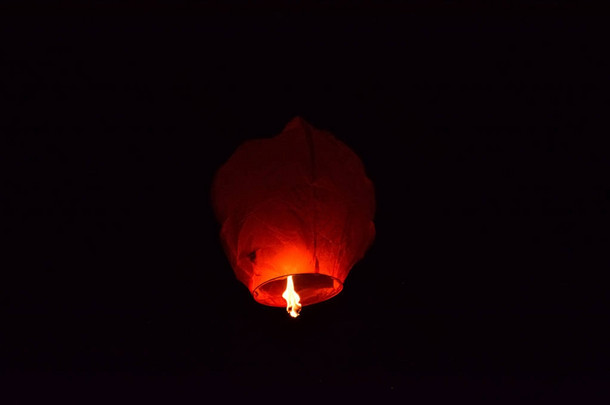 在半空中的黑暗的夜空上漂浮的灯笼