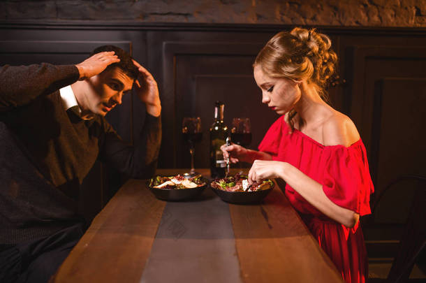 年轻夫妇在餐馆吵架, 糟糕的浪漫约会。<strong>典雅</strong>的妇女在红色礼服和英俊的人用餐 