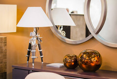 现代客房设计。热的抽屉与台灯的三脚架, 铜圆装饰花瓶.
