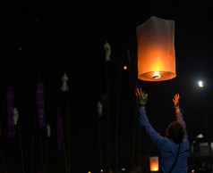 灯节春节的亚洲男子手持漂浮的天空灯笼