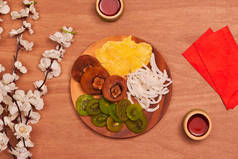 越南菜越南春节假期, 也亚洲农历新年, 丰富多彩的蜜饯作为猕猴桃, 李子果酱, 或椰子果酱设置在白色的板材与绿色的木背景