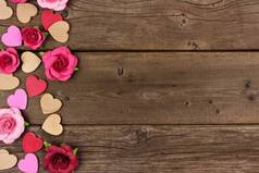 情人节侧边木心和纸玫瑰对一个质朴的木材背景与复制空间.
