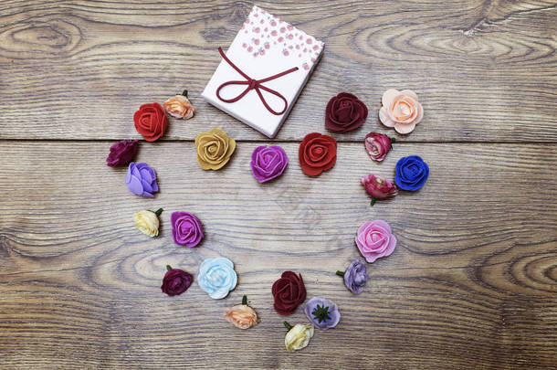 情人节礼品卡的概念。礼品盒与小组玫瑰在木桌上。具有复制空间的顶部视图