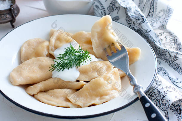 奶酪与传统的陶瓷板的荨麻的饺子。俄罗斯传统美食