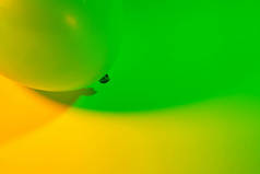 简单的抽象单气球颜色渐变背景由两个五颜六色的灯光相互转换。绿色和黄色.