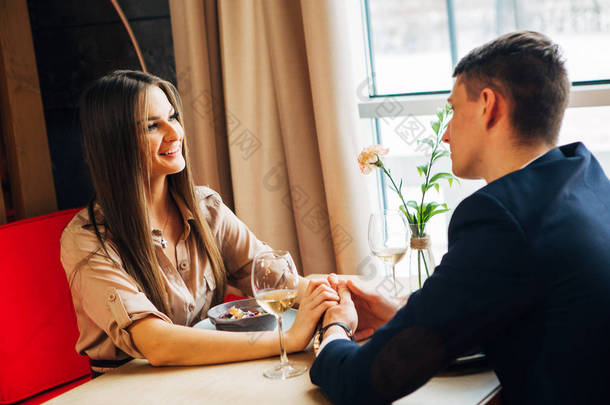 年轻快乐情侣浪漫约会在餐厅喝一杯白酒, 庆祝情人节