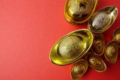 金锭为农历新年喜庆装饰品在红色背景。汉字意味着运气, 财富和繁荣, 如图所示.