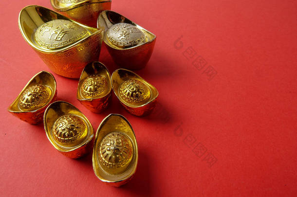 金锭为农历<strong>新年喜庆</strong>装饰品在红色背景。汉字意味着运气, 财富和繁荣, 如图所示.