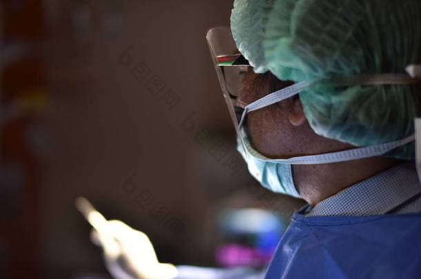 手术室里的手术灯为外科手术的开始和切口做准备。在手术室里工作的团队医生。现代医院手术室的创新技术.