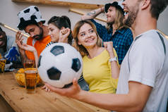 情感多文化群的朋友看足球比赛在酒吧 
