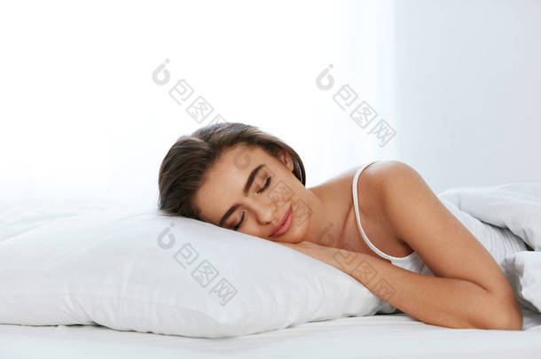 白色床上用品。睡在床垫上的女人, 床上<strong>柔软</strong>的枕头。高分辨率.