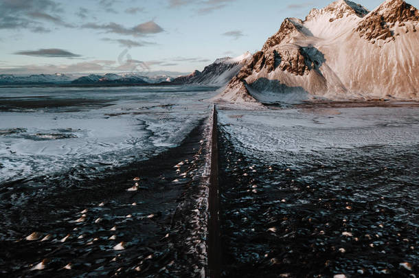 在冰岛 Stokksnes, 一条通向高山<strong>的</strong>道路, 覆盖着积<strong>雪</strong>。<strong>照片</strong>是用无人机拍摄<strong>的</strong>.